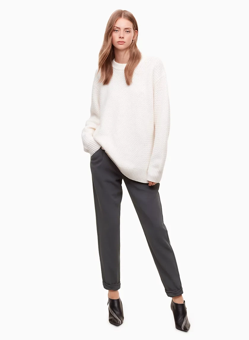 50 Thermal Layering Outfits for Cold January Days That Are Chic, Warm and Elegant 6 Black Thermal Top under a Cream Chunky Knit Sweater with Grey Trousers and Black Ankle Boots
