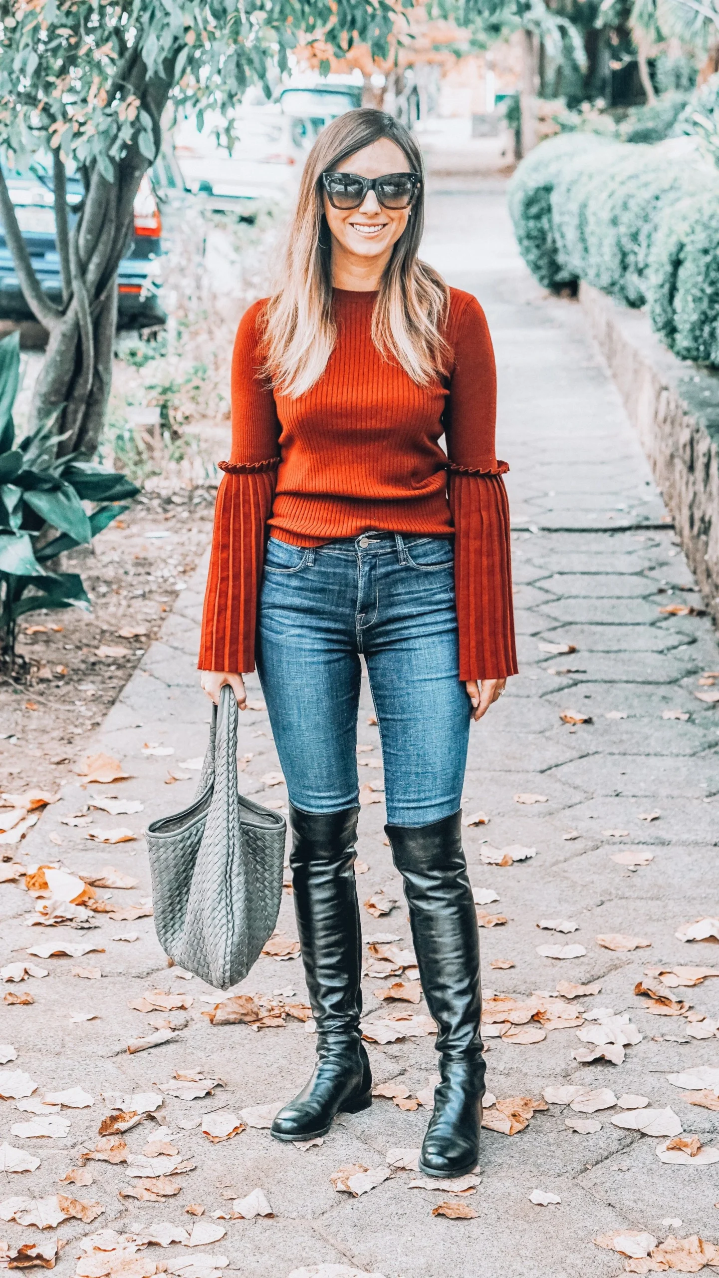 50 Thermal Layering Outfits for Cold January Days That Are Chic, Warm and Elegant 23 Grey Thermal Top under a Rust Knit Sweater with Blue Jeans and Black Knee-high Boots