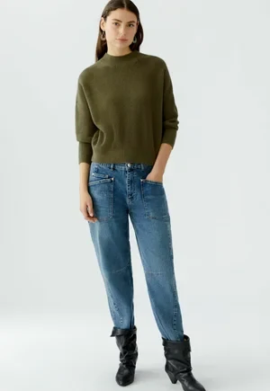 50 Thermal Layering Outfits for Cold January Days That Are Chic, Warm and Elegant 27 Black Thermal Top under a Olive Knit Sweater with Blue Jeans and Black Ankle Boots
