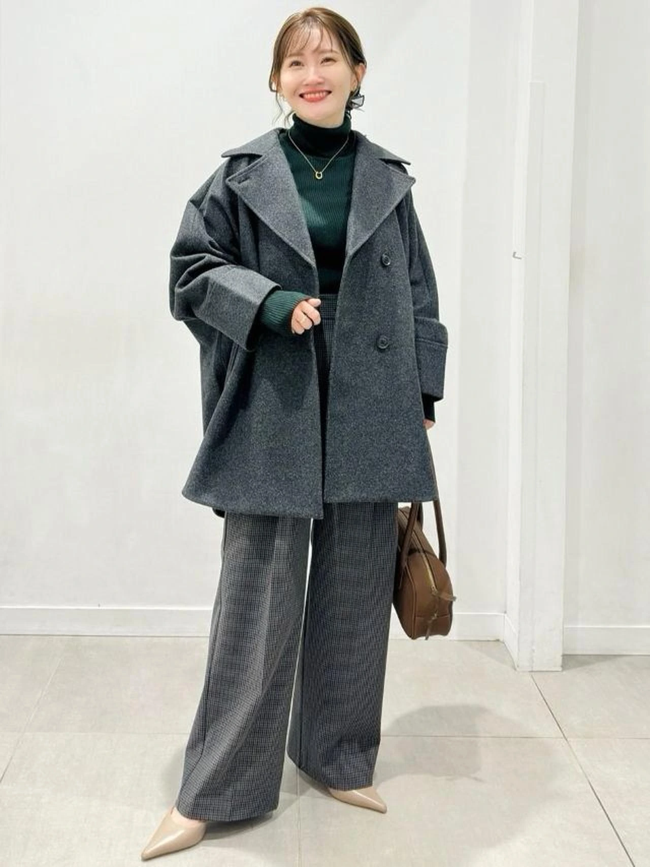 Forest green turtleneck, wide-leg trousers with a wool coat and low-heeled pumps