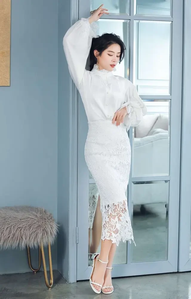 Cream lace blouse and wrap skirt outfit with black pointed heels and silver drop earrings