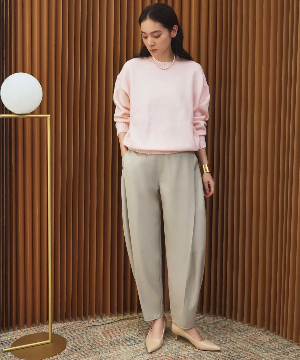 Pale pink knit sweater and trouser outfit with kitten heels and a pearl bracelet