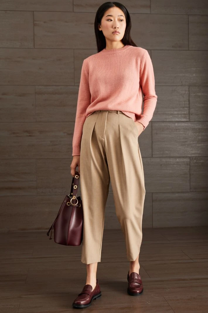 Rose pink sweater and tailored trouser outfit with smart loafers and a small structured clutch