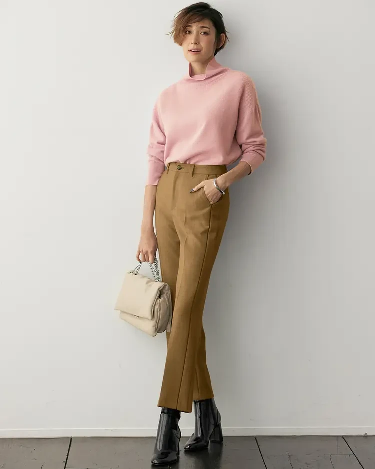 Dusty pink fine knit sweater outfit with straight-leg trousers, leather ankle boots and a small structured clutch