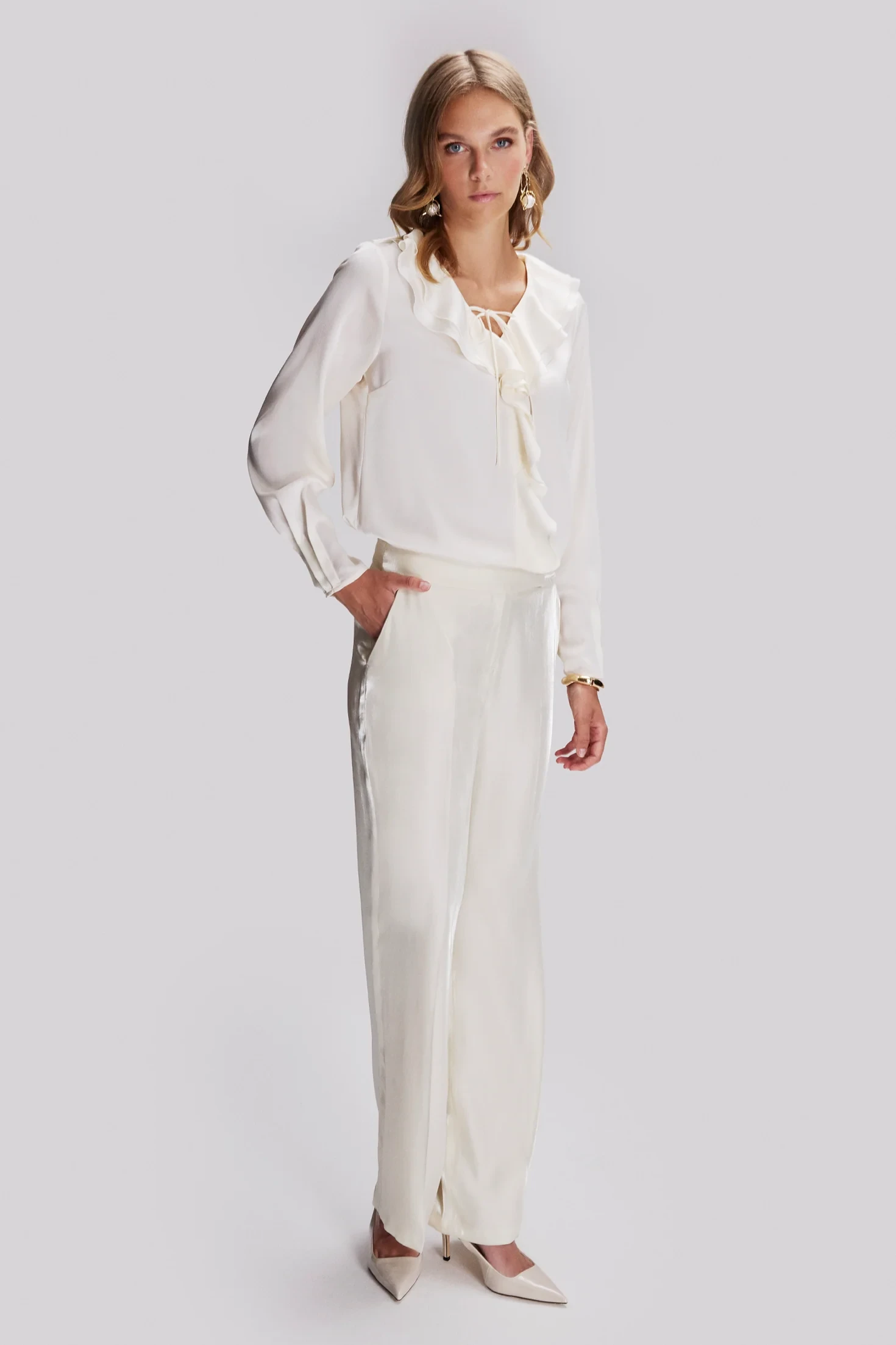 Ivory ruffle blouse and satin trouser outfit with low-heeled pumps and a cashmere wrap