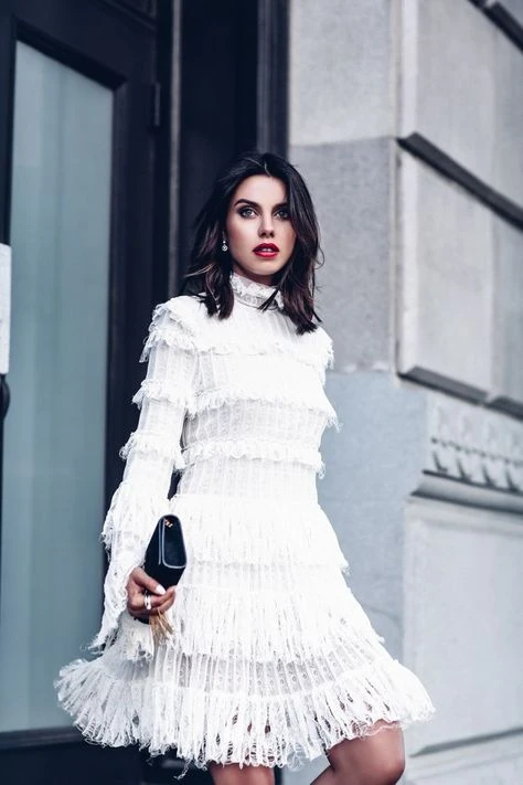 White lace tiered dress with leather ankle boots and statement earrings